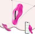 A close-up of a bright pink intimate device with a metallic inner channel, shown against a pale skin-toned background with a smartphone displaying a companion app and a small detached matching piece nearby.
