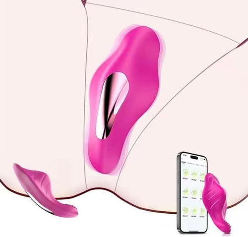 A close-up of a bright pink intimate device with a metallic inner channel, shown against a pale skin-toned background with a smartphone displaying a companion app and a small detached matching piece nearby.
